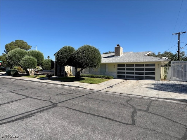 1819 Beverly Way, Las Vegas, NV 89104 - view of front of house with an attached garage, a chimney, and concrete driveway