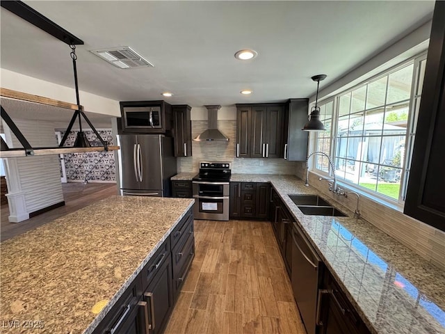 1819 Beverly Way, Las Vegas, NV 89104 - kitchen with appliances with stainless steel finishes, a sink, wall chimney range hood, backsplash, and light stone countertops