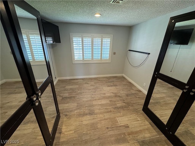 1819 Beverly Way, Las Vegas, NV 89104 - spare room featuring plenty of natural light, a textured ceiling, wood finished floors, and baseboards