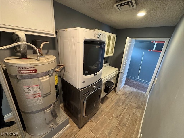 1819 Beverly Way, Las Vegas, NV 89104 - laundry area featuring light wood-style floors, stacked washing machine and dryer, a textured ceiling, and electric water heater