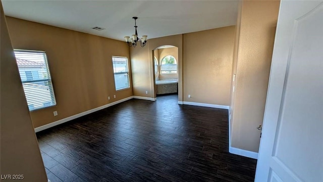 8159 Base Camp Ave, Las Vegas, NV 89178 - spare room featuring baseboards, arched walkways, wood finished floors, and a chandelier