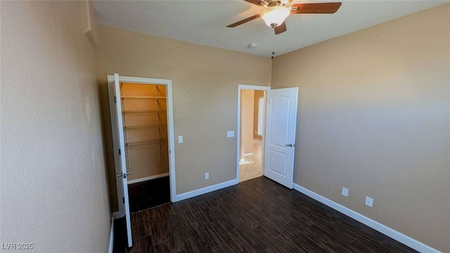 8159 Base Camp Ave, Las Vegas, NV 89178 - unfurnished bedroom with baseboards, dark wood finished floors, a spacious closet, and a closet