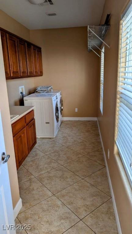 8159 Base Camp Ave, Las Vegas, NV 89178 - washroom with plenty of natural light, cabinet space, washing machine and dryer, and light tile patterned floors