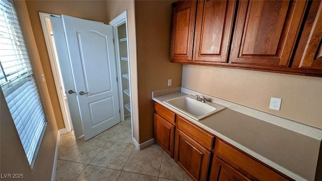 8159 Base Camp Ave, Las Vegas, NV 89178 - kitchen featuring brown cabinetry, light tile patterned floors, and light countertops
