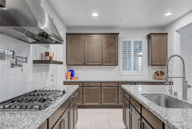 2669 Via Monet, Henderson, NV 89044 - kitchen with extractor fan, stainless steel gas stovetop, a sink, tasteful backsplash, and light stone counters