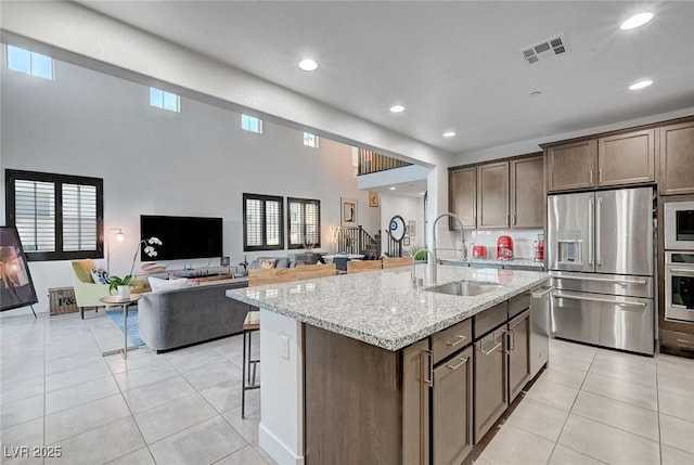 2669 Via Monet, Henderson, NV 89044 - kitchen featuring stainless steel appliances, a sink, a breakfast bar, light tile patterned flooring, and recessed lighting