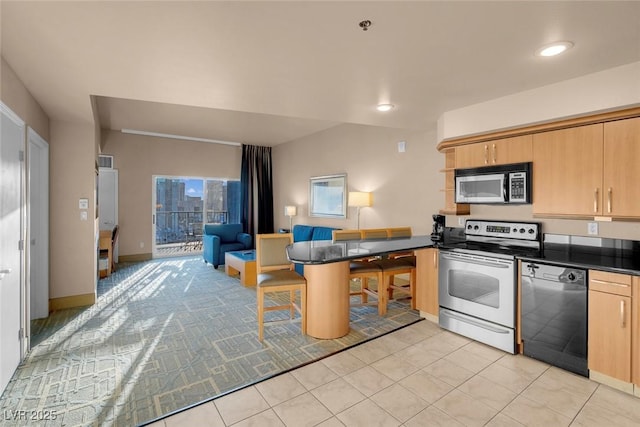 211 E Flamingo Rd Unit 1617, Las Vegas, NV 89169 - kitchen featuring stainless steel appliances, a peninsula, open floor plan, light brown cabinets, and dark countertops