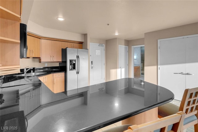 211 E Flamingo Rd Unit 1617, Las Vegas, NV 89169 - kitchen with stainless steel fridge, dark countertops, a sink, open shelves, and a peninsula