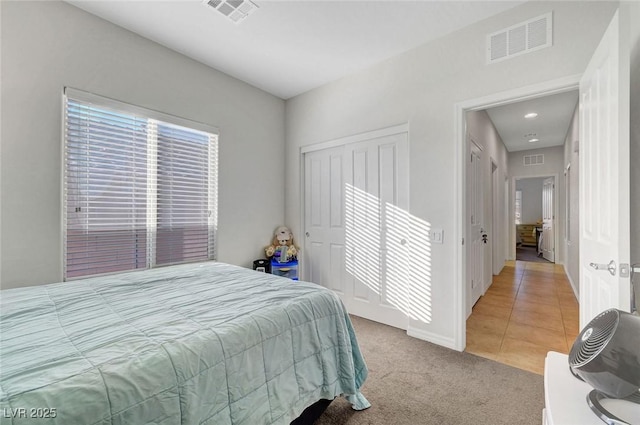 2613 Velodrome Ct, Henderson, NV 89044 - bedroom with light carpet, baseboards, light tile patterned floors, and a closet