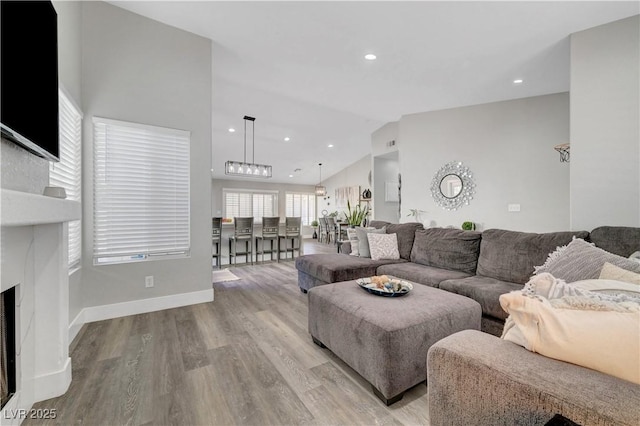 2711 Briarcliff Ave, Henderson, NV 89074 - living area featuring vaulted ceiling, wood finished floors, recessed lighting, baseboards, and a fireplace