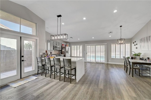 2711 Briarcliff Ave, Henderson, NV 89074 - kitchen featuring stainless steel appliances, light wood-style flooring, a chandelier, light countertops, and a peninsula