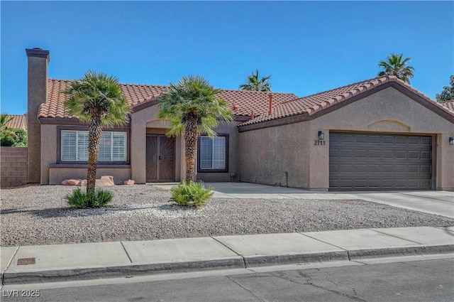 2711 Briarcliff Ave, Henderson, NV 89074 - view of front of home with a tiled roof, stucco siding, a garage, driveway, and a chimney