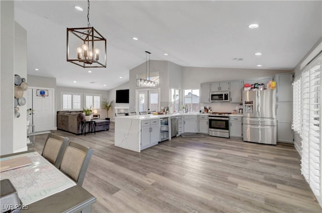 2711 Briarcliff Ave, Henderson, NV 89074 - kitchen featuring appliances with stainless steel finishes, open floor plan, a chandelier, a peninsula, and a sink