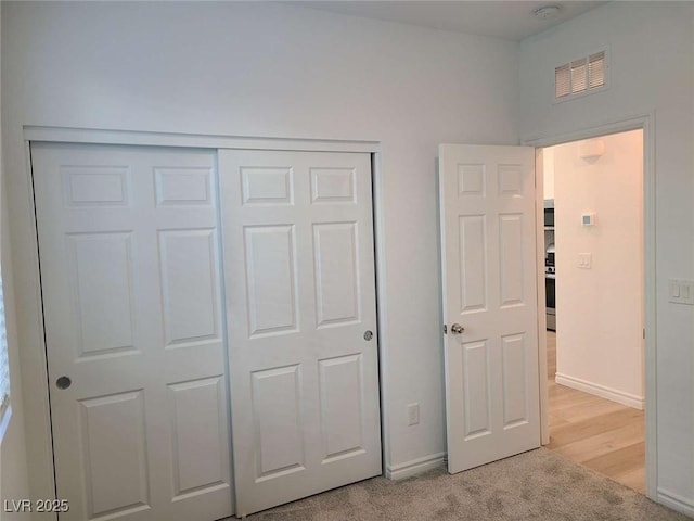7332 N Decatur Blvd Unit 2, North Las Vegas, NV 89084 - unfurnished bedroom featuring a closet, baseboards, and light carpet