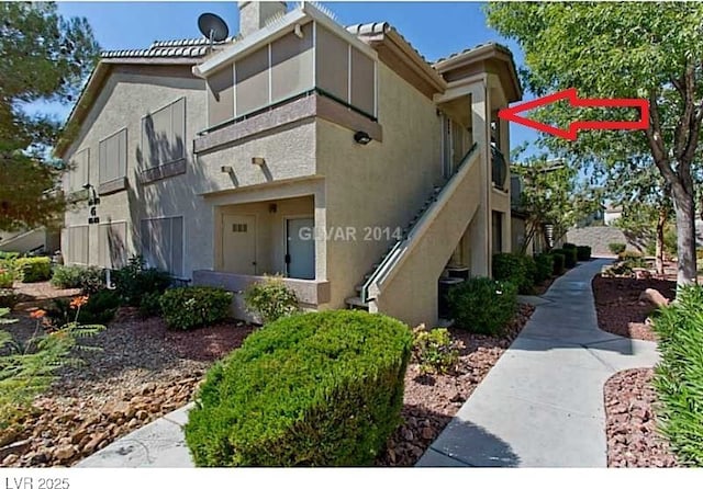 5710 E Tropicana Ave Unit 2178, Las Vegas, NV 89122 - view of side of property with stucco siding, stairway, and a chimney