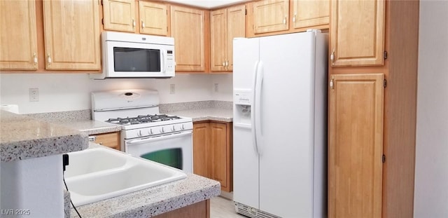 5710 E Tropicana Ave Unit 2178, Las Vegas, NV 89122 - kitchen featuring white appliances, light brown cabinetry, and a sink