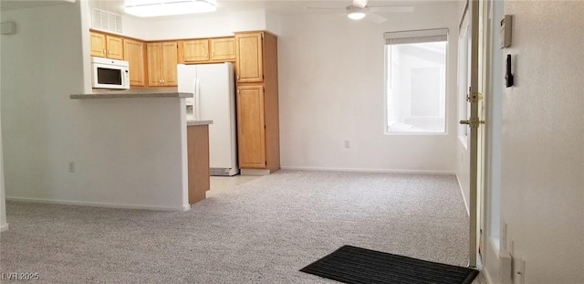 5710 E Tropicana Ave Unit 2178, Las Vegas, NV 89122 - kitchen with white appliances, light colored carpet, a ceiling fan, and baseboards