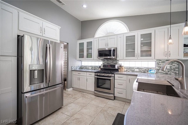 6417 Fisher Ave, Las Vegas, NV 89130 - kitchen with appliances with stainless steel finishes, tasteful backsplash, a sink, white cabinets, and recessed lighting