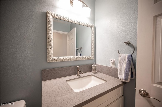 6417 Fisher Ave, Las Vegas, NV 89130 - bathroom featuring vanity, a textured wall, and toilet