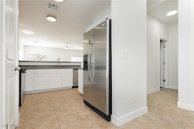 3041 Gary Cooper St Unit 103, Las Vegas, NV 89122 - kitchen with stainless steel appliances, dark countertops, white cabinets, a sink, and light tile patterned flooring