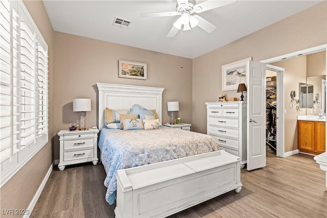 7669 Fieldfare Dr, North Las Vegas, NV 89084 - bedroom with wood finished floors, baseboards, multiple windows, and a walk in closet