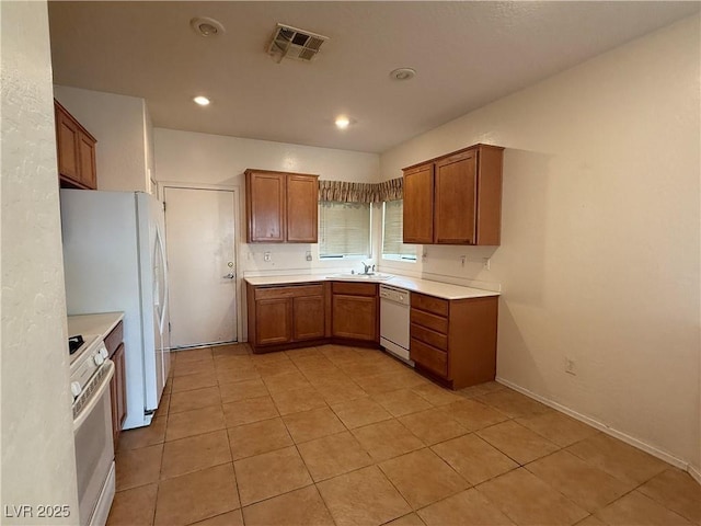 3508 Kittiwake Rd, North Las Vegas, NV 89084 - kitchen featuring white appliances, a sink, brown cabinetry, light countertops, and recessed lighting