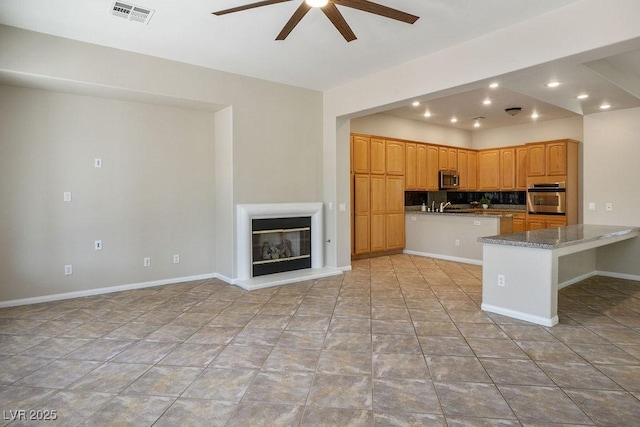 5017 Kaibab Forest Ave, Las Vegas, NV 89141 - kitchen featuring stainless steel appliances, a ceiling fan, a peninsula, tasteful backsplash, and a sink