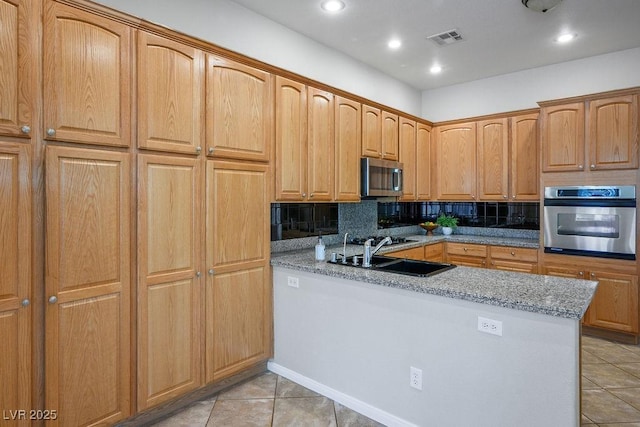 5017 Kaibab Forest Ave, Las Vegas, NV 89141 - kitchen with stainless steel appliances, a sink, light tile patterned floors, a peninsula, and recessed lighting