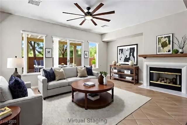 5017 Kaibab Forest Ave, Las Vegas, NV 89141 - living room featuring a ceiling fan, plenty of natural light, light tile patterned floors, and a glass covered fireplace
