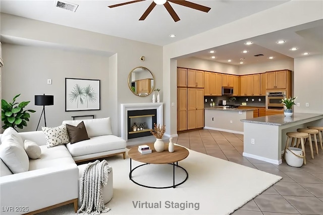 5017 Kaibab Forest Ave, Las Vegas, NV 89141 - living area with light tile patterned flooring, ceiling fan, recessed lighting, and a glass covered fireplace