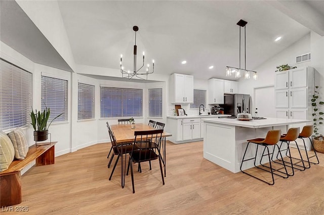 58 Pleasant Dale Dr, Henderson, NV 89074 - kitchen with stainless steel fridge, lofted ceiling, a sink, light countertops, and light wood finished floors