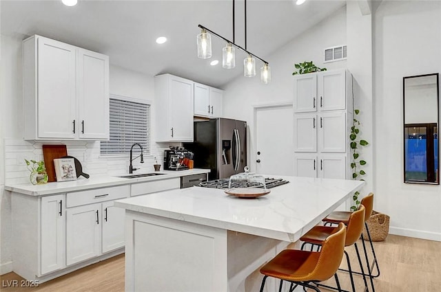 58 Pleasant Dale Dr, Henderson, NV 89074 - kitchen with stainless steel refrigerator with ice dispenser, a sink, gas stovetop, light wood-style floors, and backsplash