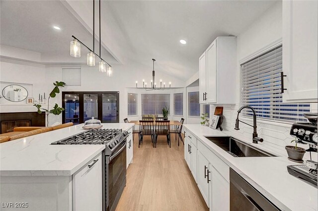 58 Pleasant Dale Dr, Henderson, NV 89074 - kitchen featuring a sink, appliances with stainless steel finishes, backsplash, light wood-type flooring, and white cabinets