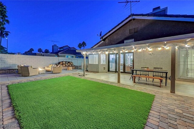 58 Pleasant Dale Dr, Henderson, NV 89074 - yard at night featuring outdoor lounge area and a patio area