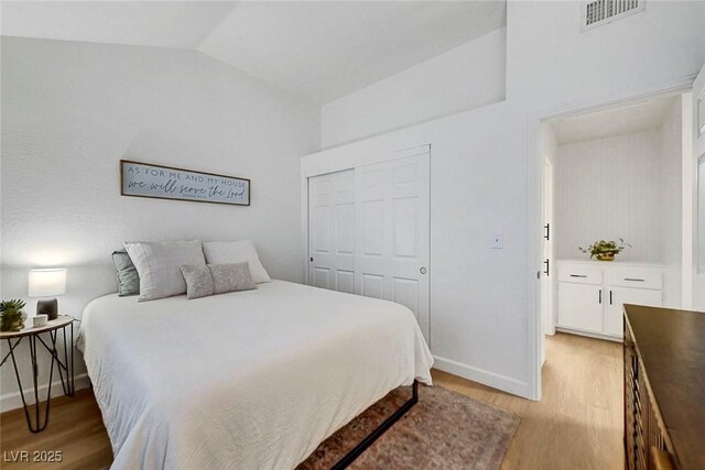 58 Pleasant Dale Dr, Henderson, NV 89074 - bedroom with light wood-style floors, vaulted ceiling, a closet, and baseboards