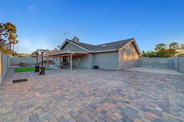 58 Pleasant Dale Dr, Henderson, NV 89074 - rear view of property with a fenced backyard, a chimney, a patio area, a gate, and stucco siding