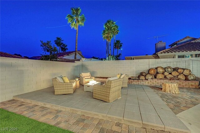 58 Pleasant Dale Dr, Henderson, NV 89074 - patio at night featuring a patio, a fenced backyard, and an outdoor living space with a fire pit
