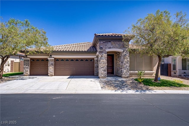 8544 Garden Valley Ct, Las Vegas, NV 89178 - mediterranean / spanish home with a garage, a tiled roof, stone siding, driveway, and stucco siding