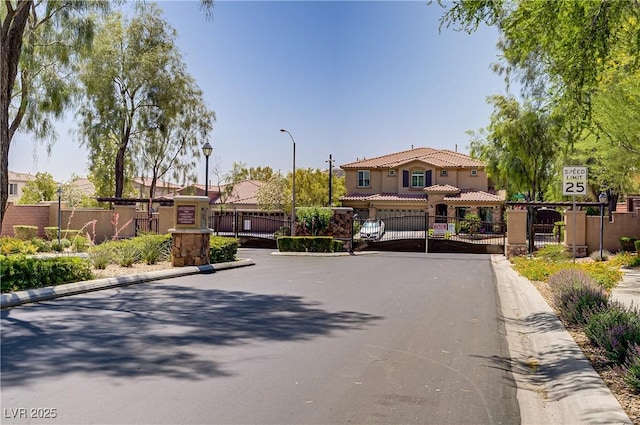 8544 Garden Valley Ct, Las Vegas, NV 89178 - view of asphalt street with a gate, curbs, a gated entry, and street lighting