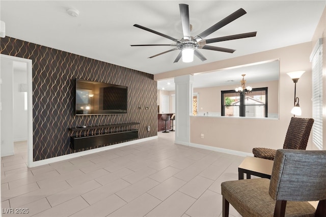 11755 Garland Grove Ln, Las Vegas, NV 89183 - living room featuring an accent wall, a ceiling fan, baseboards, a chandelier, and decorative columns