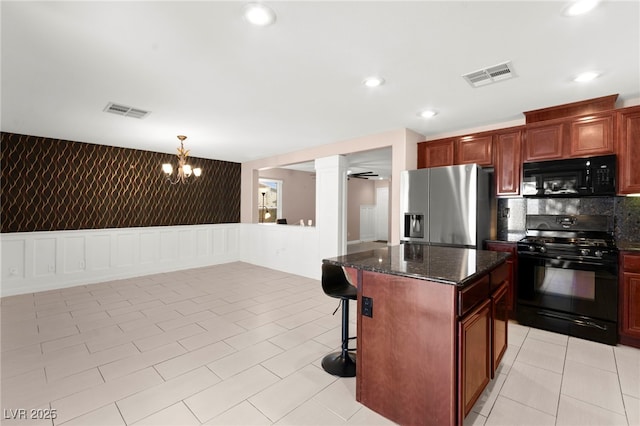 11755 Garland Grove Ln, Las Vegas, NV 89183 - kitchen with black appliances, decorative columns, a kitchen bar, a kitchen island, and backsplash
