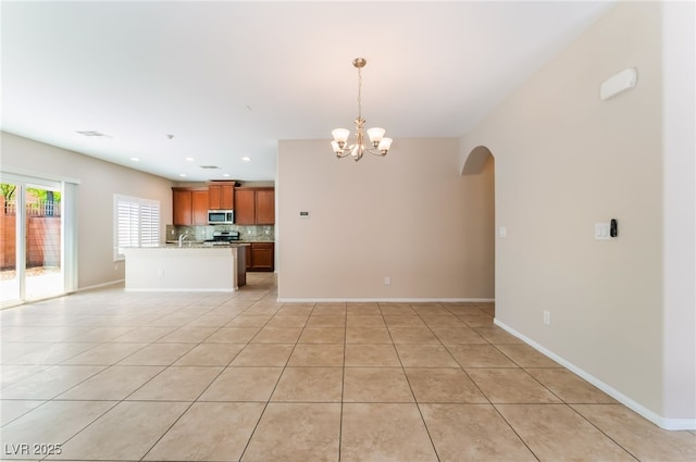 6125 Paddleboat St, North Las Vegas, NV 89031 - unfurnished living room with arched walkways, a chandelier, light tile patterned floors, baseboards, and recessed lighting