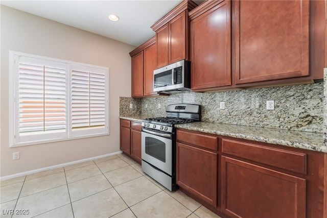 6125 Paddleboat St, North Las Vegas, NV 89031 - kitchen with appliances with stainless steel finishes, decorative backsplash, baseboards, light stone counters, and recessed lighting