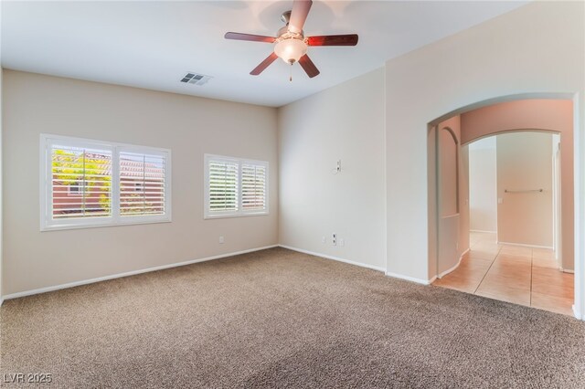 6125 Paddleboat St, North Las Vegas, NV 89031 - spare room featuring light colored carpet, arched walkways, ceiling fan, and baseboards