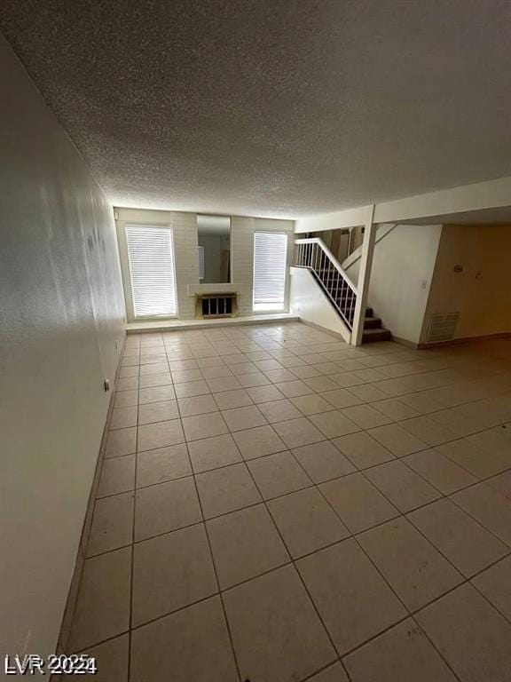 5243 Sunnywood Dr, Las Vegas, NV 89120 - basement featuring a textured ceiling, tile patterned flooring, and stairs