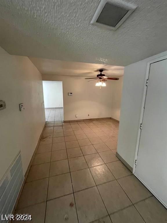 5243 Sunnywood Dr, Las Vegas, NV 89120 - empty room featuring a textured ceiling, light tile patterned flooring, a ceiling fan, and baseboards