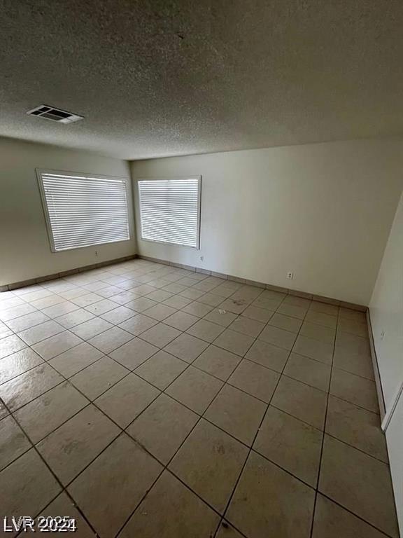 5243 Sunnywood Dr, Las Vegas, NV 89120 - unfurnished room featuring light tile patterned flooring, a textured ceiling, and baseboards