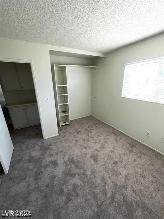 5243 Sunnywood Dr, Las Vegas, NV 89120 - unfurnished bedroom featuring a textured ceiling, carpet floors, and a closet