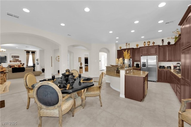 6739 Quapaw St, Las Vegas, NV 89149 - kitchen with stainless steel appliances, open floor plan, light stone counters, arched walkways, and recessed lighting