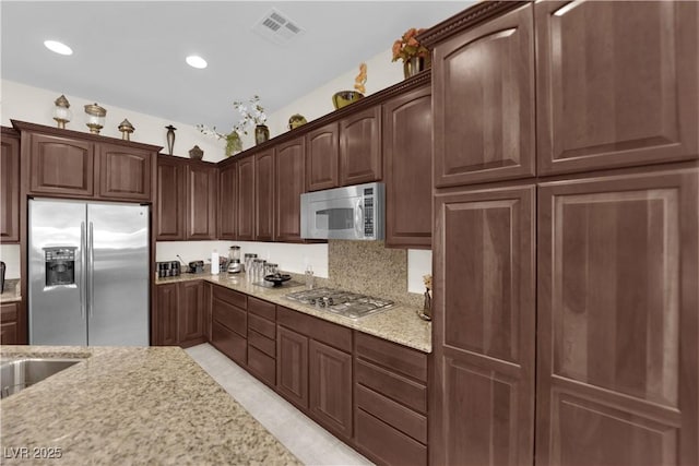 6739 Quapaw St, Las Vegas, NV 89149 - kitchen with appliances with stainless steel finishes, light stone countertops, recessed lighting, and dark brown cabinetry